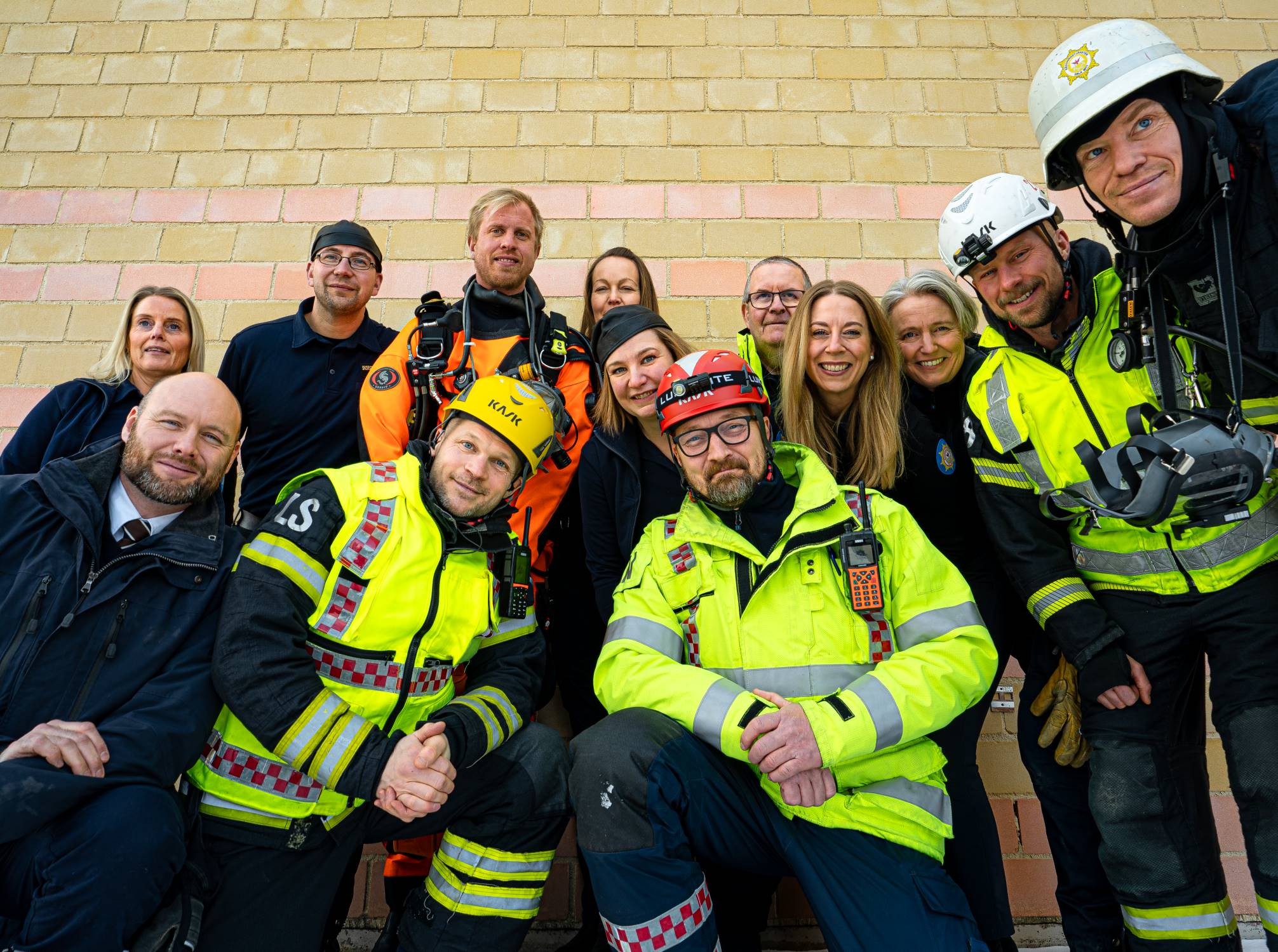 Syntolkning av bild: Brandmän i grupp vid höjdfordon