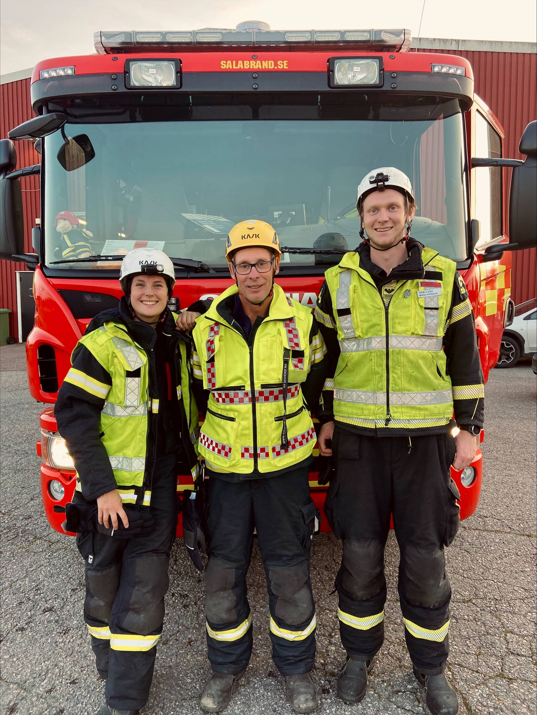 Syntolkning av bild: Brandman med hjälm som tittar på en brandbil
